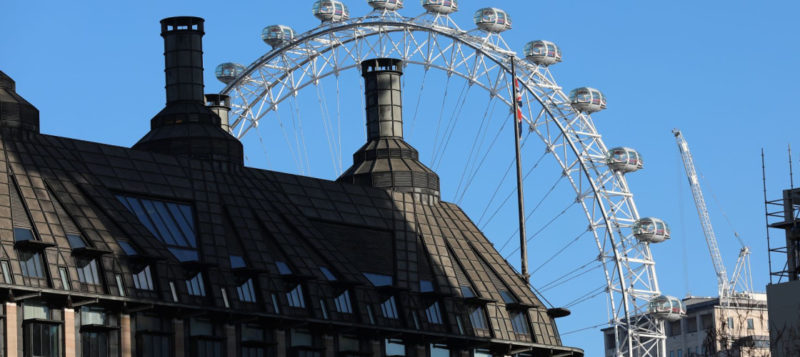 A view of the London Eye behind Portcullis House in Westminster